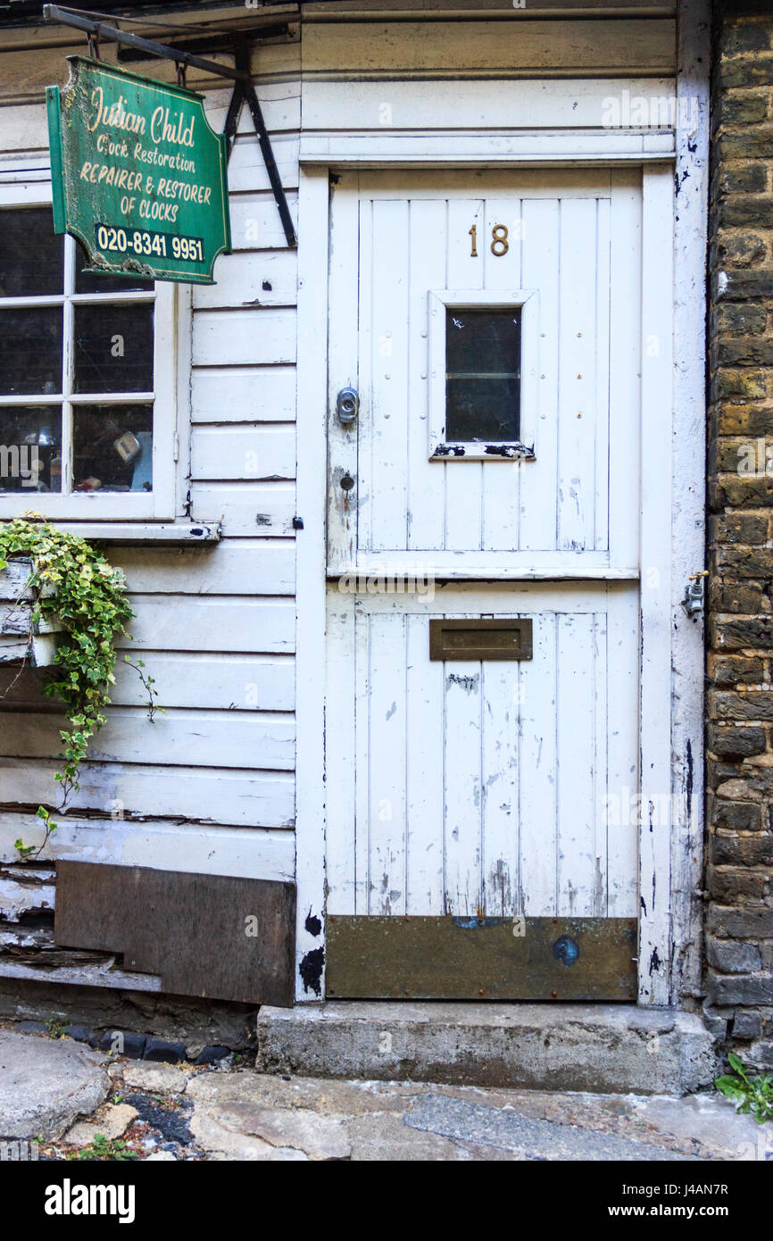 Verniciato bianco porta in legno e segno verde dei locali di Julian Orologio bambino restauro, Highgate Village, LONDRA, REGNO UNITO, poiché spostato Foto Stock