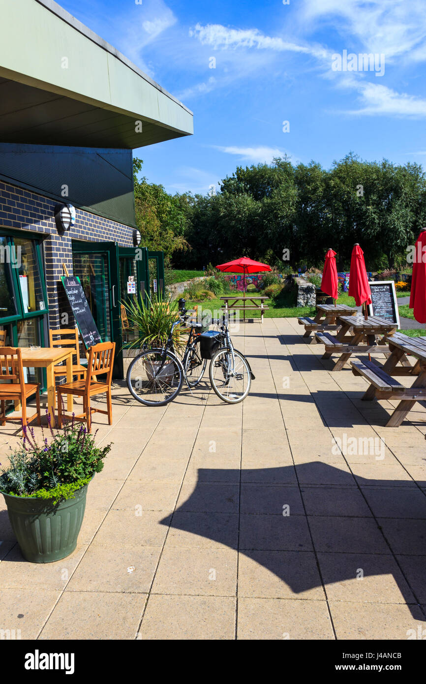 Tavoli e ombrelloni fuori il cafe di Markfield (Park, Tottenham, London, Regno Unito Foto Stock