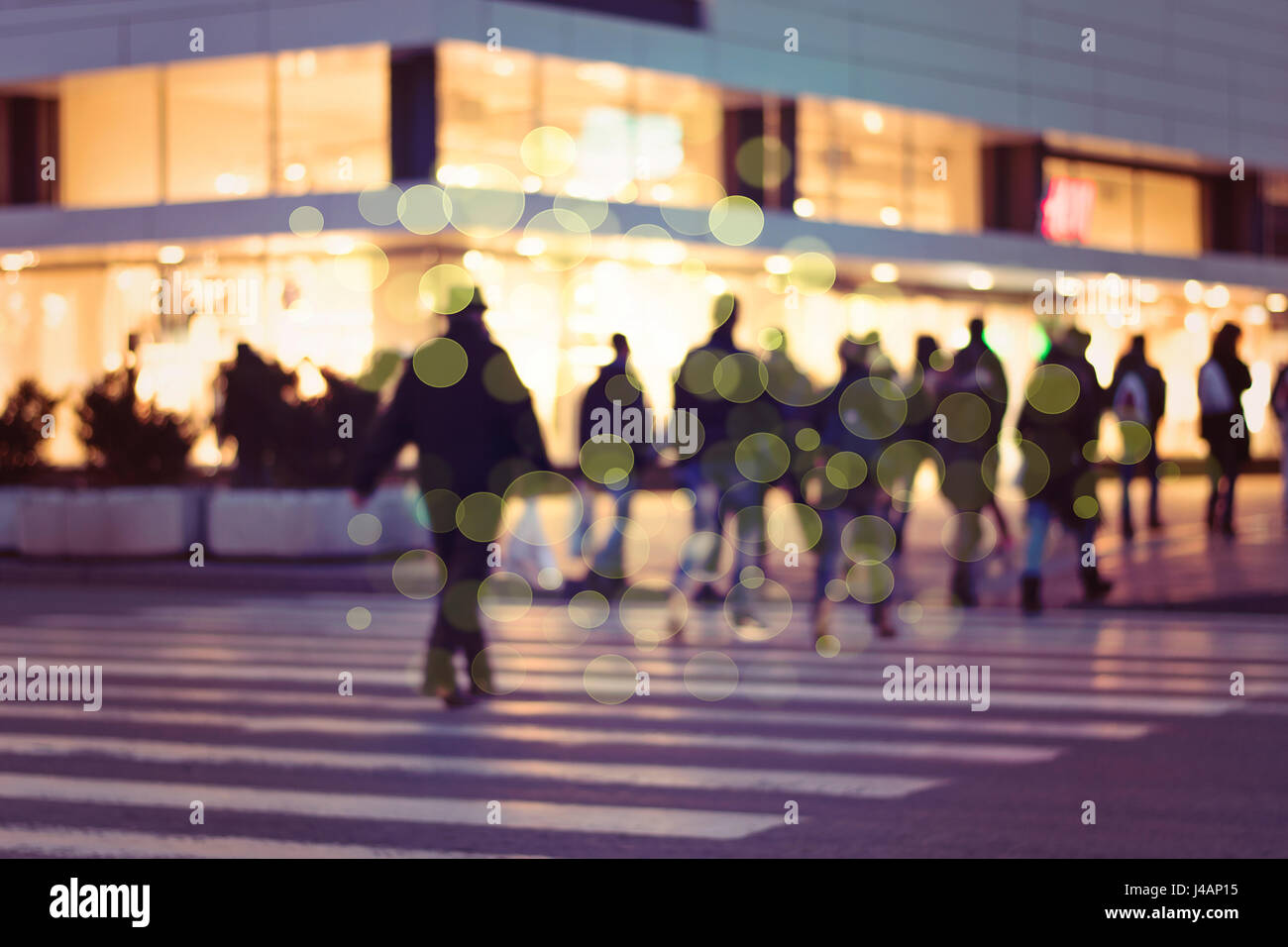 Immagine con sfocatura di movimento di una folla di persone che attraversano una strada di città all'attraversamento pedonale Foto Stock