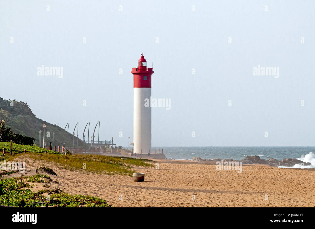 La vegetazione verde spiaggia e faro rosso in rocce Umshlanga a Durban in Sud Africa Foto Stock