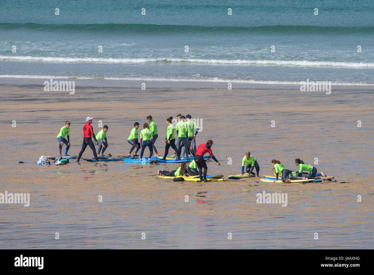 Scuola di Surf istruttori novizi di insegnamento su Fistral Beach in Newquay Cornwall fuga Scuola Surf Surf Surfer ai partecipanti il coaching di apprendimento Foto Stock