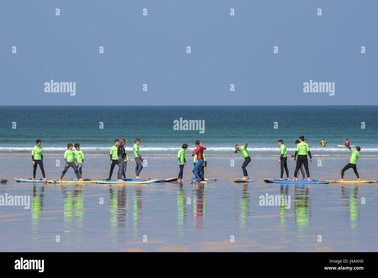 Una scuola di surf istruttore insegnamento novizi Fistral Beach in Newquay Cornwall fuga Scuola Surf Surf Surfer ai partecipanti il coaching di apprendimento Foto Stock