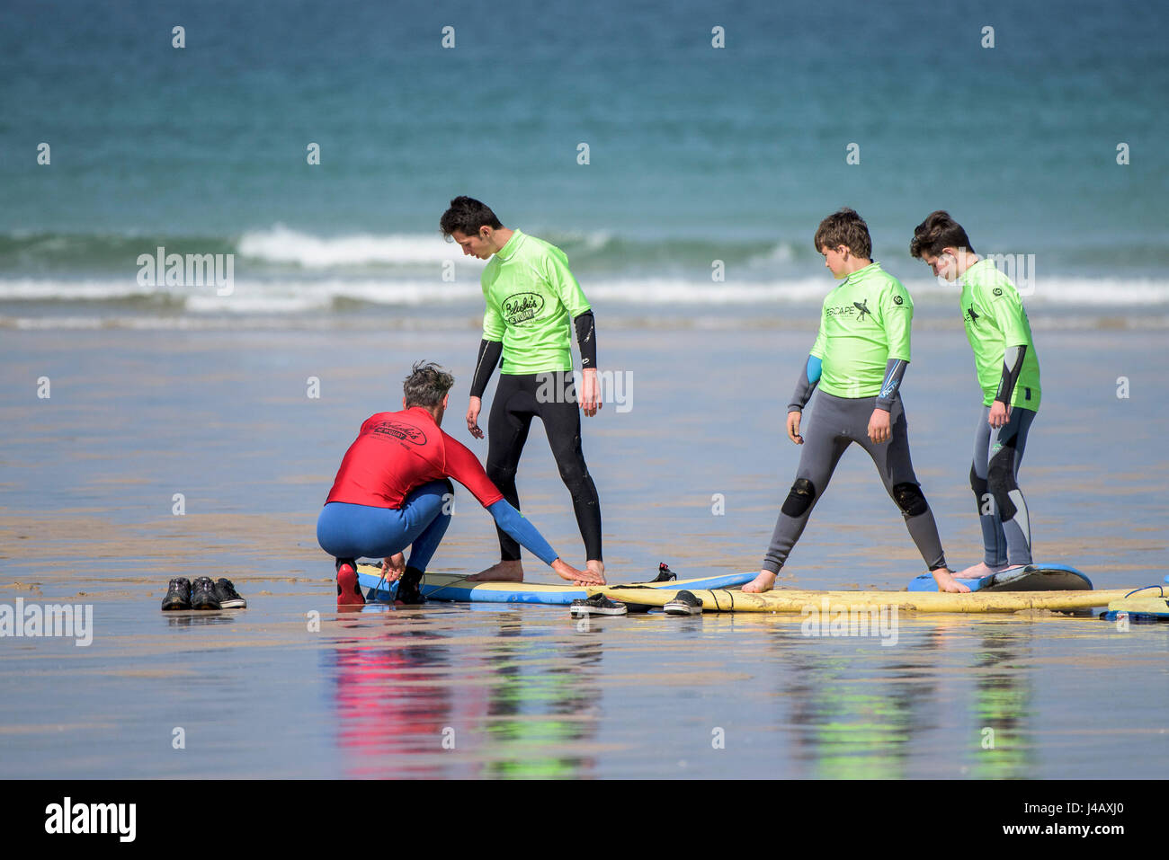 Una scuola di surf istruttore insegnamento novizi Newquay Cornwall Surf Surfer ai partecipanti imparare Coaching Didattica istruire Foto Stock
