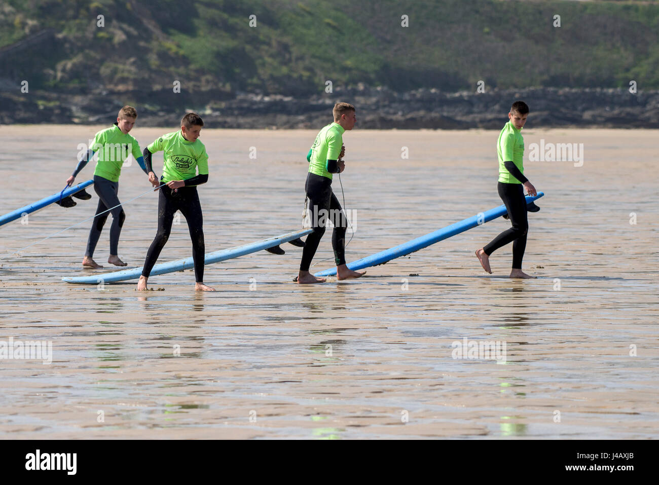 Un gruppo di novizi a piedi al mare; fuga Scuola Surf; Fistral Beach;, Newquay Cornwall; Surf; Surfers; Surf; studenti; apprendimento Foto Stock