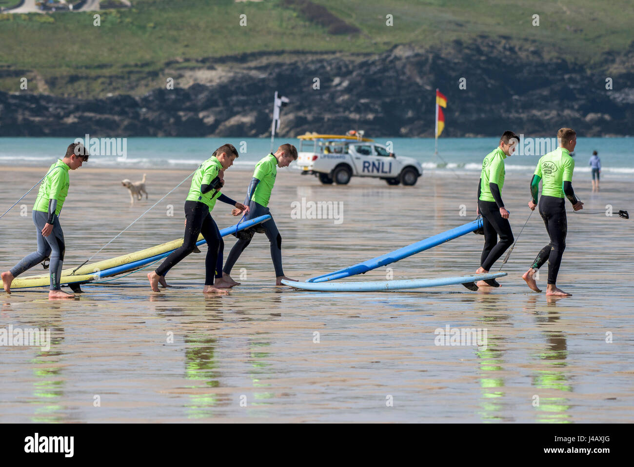 Un gruppo di novizi a piedi al mare; fuga Scuola Surf; Fistral Beach;, Newquay Cornwall; Surf; Surfers; Surf; studenti; apprendimento Foto Stock