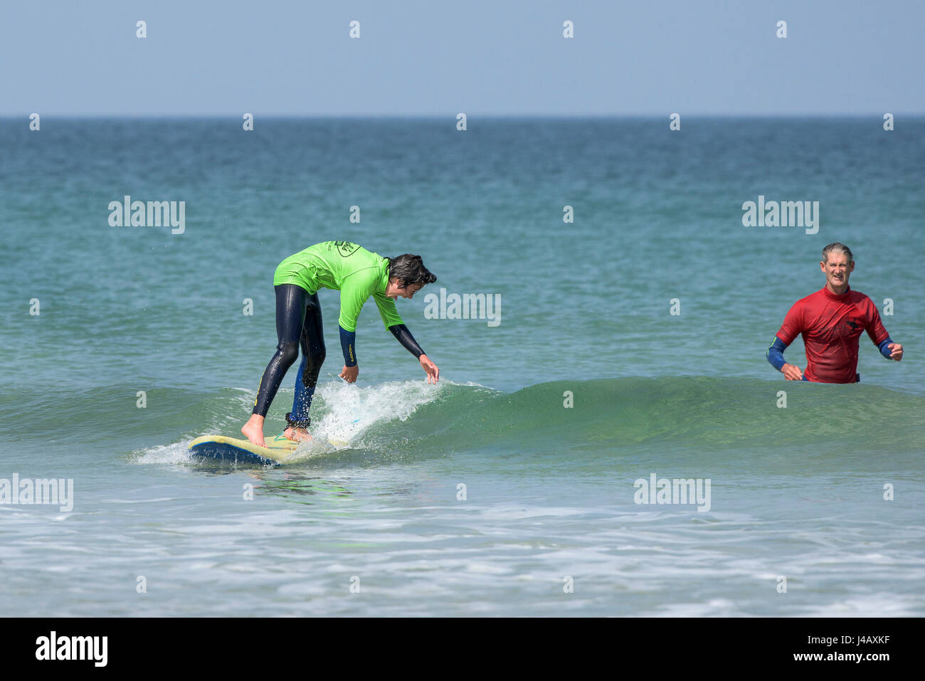 Una scuola di surf istruttore novizi di insegnamento su Fistral Beach in Newquay Cornwall Surf Surfer allievo insegnamento apprendimento istruttore istruire Foto Stock