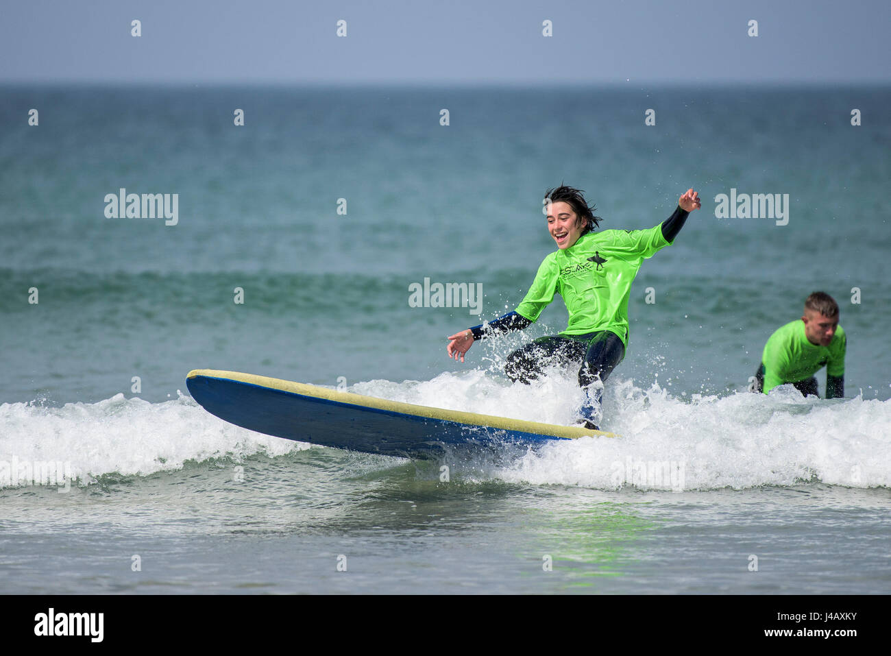 Novizi ad imparare a navigare su Fistral Beach in Newquay Cornwall fuga Scuola Surf Surf Surfer di apprendimento dello studente Mare Turismo Foto Stock