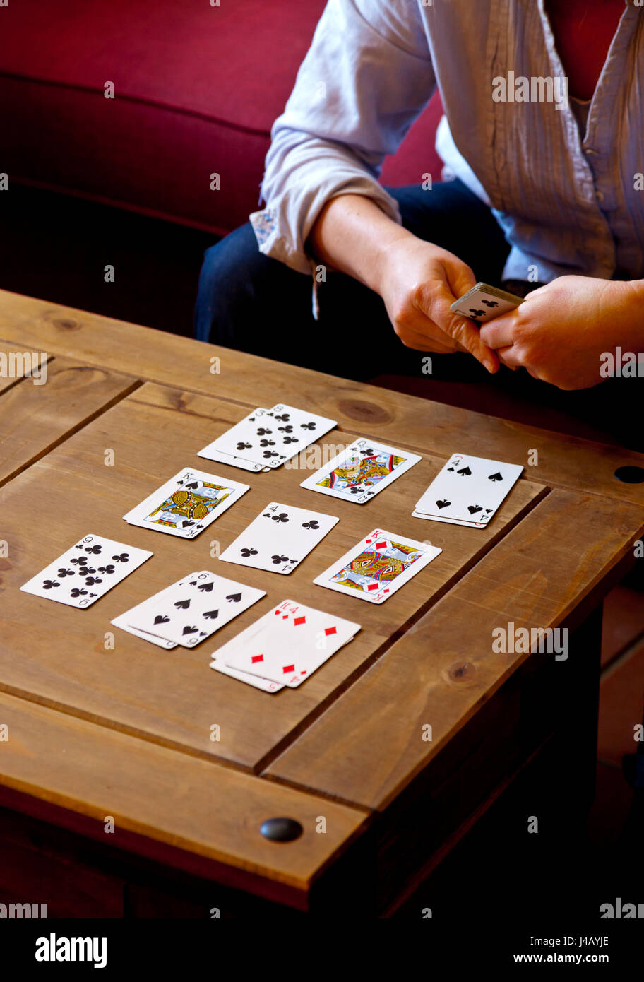 Donna Giocare Al Solitario Gioco Di Carte Su Un Basso Tavolo