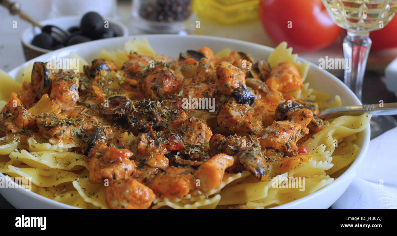 Vista ravvicinata di deliziosi piatti di pasta con salmone fresco e olive nere Foto Stock