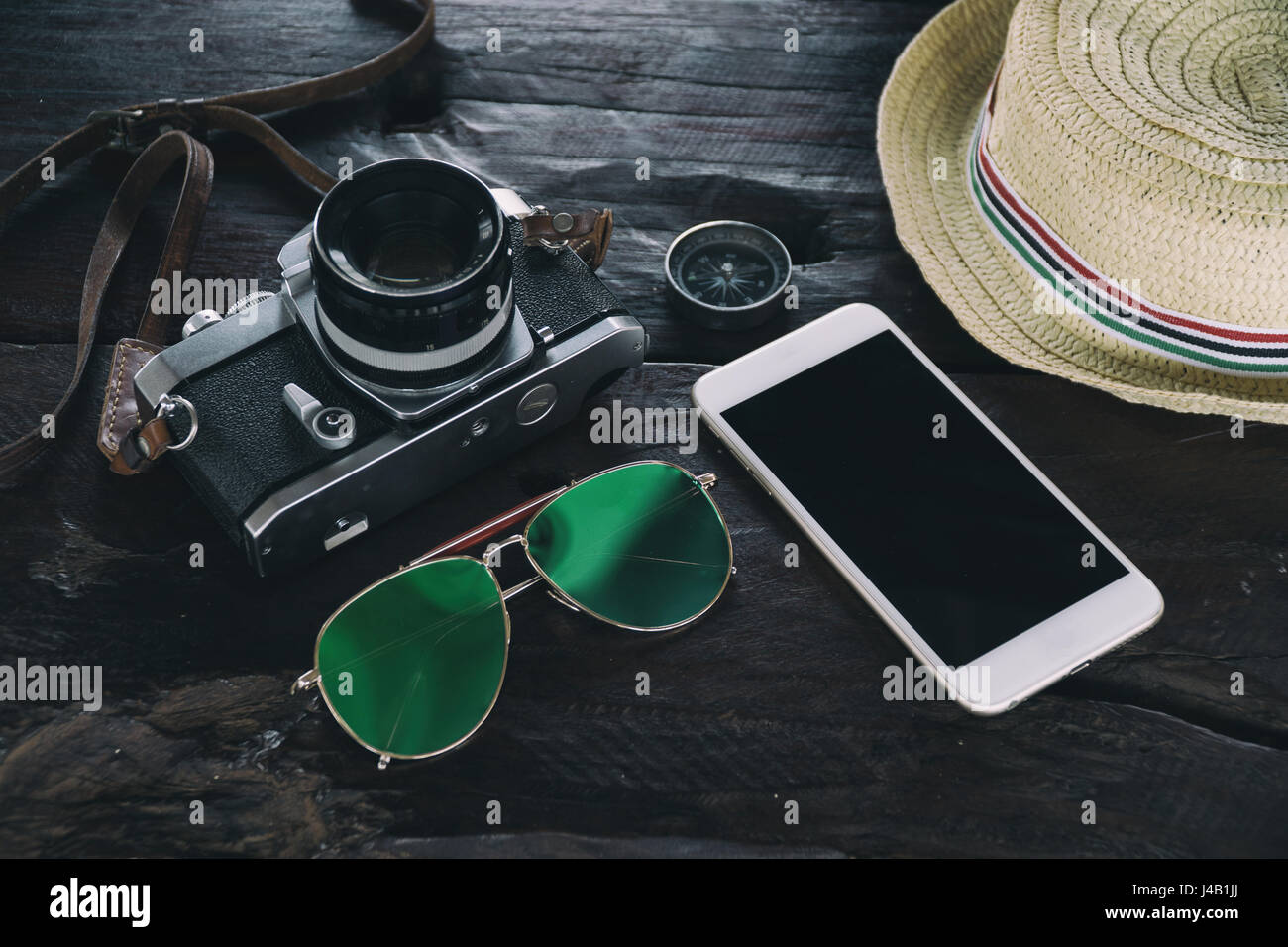 Accessori da viaggio sulla scrivania come la fotocamera occhiali bussola hat smart phone technology,attrezzature di viaggio per blogger concetto,avventura lifestyl gadget Foto Stock