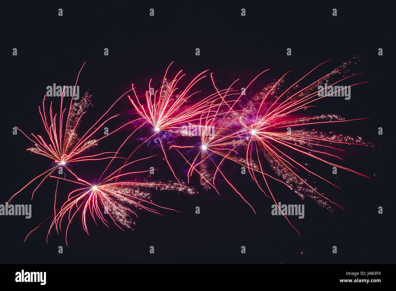 Fuochi d'artificio che esplodono in colori viola sul cielo scuro per celebrare il nuovo anno Foto Stock