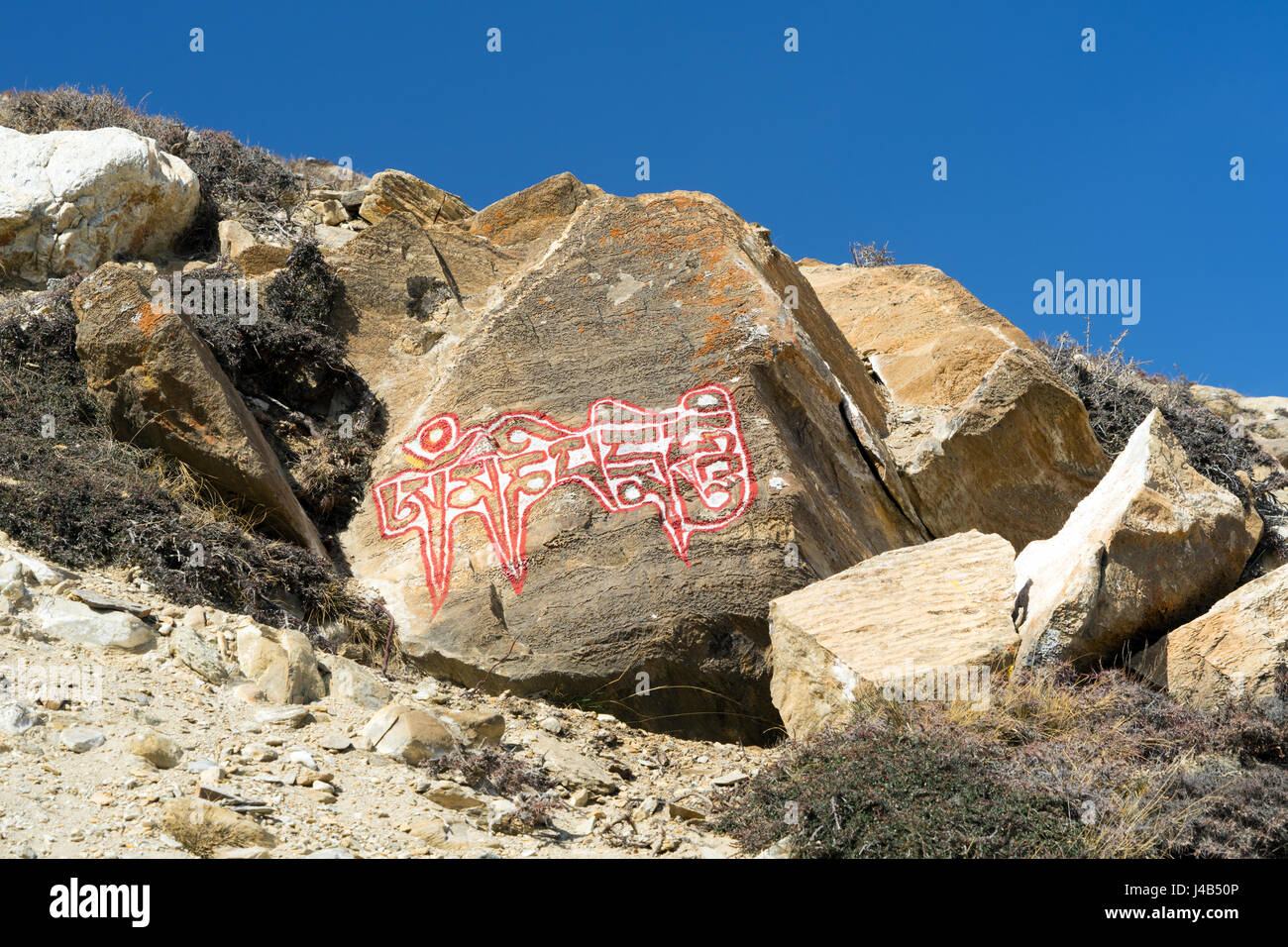 Om mani padme Hum mantra buddista scritto su una pietra. Mustang Superiore regione, Nepal. Foto Stock