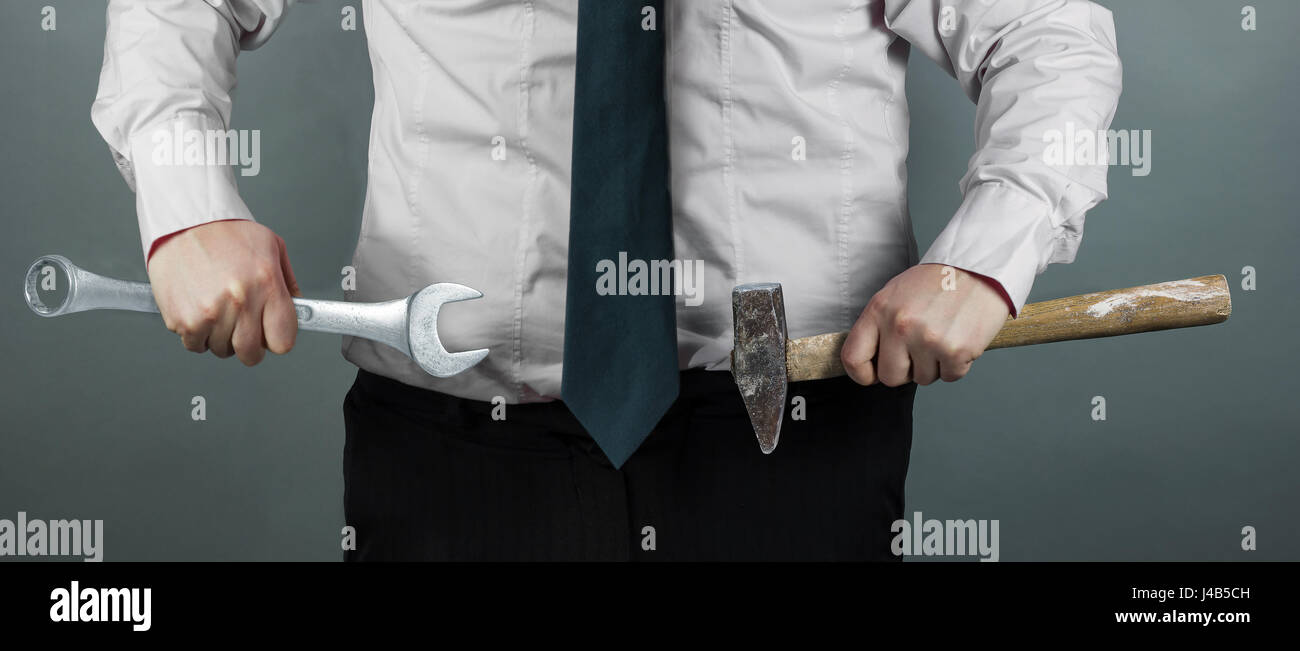 Imprenditore tenendo il martello e il filatore in mano Foto Stock