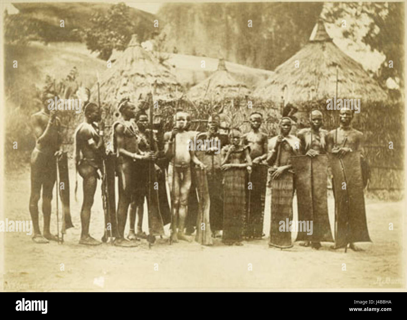 Questa immagine raffigura uomini e giovani Acholi, mostrando il loro abbigliamento tradizionale e la loro identità culturale. Gli Acholi sono un gruppo etnico diffuso principalmente in Uganda e Sudan del Sud, con una forte presenza culturale nella regione. Foto Stock