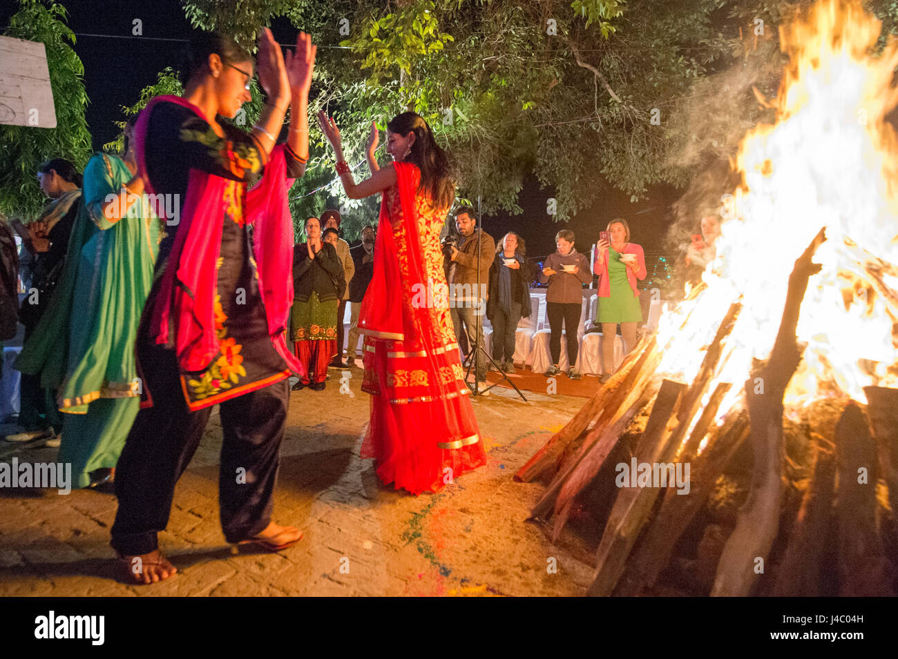 La gente ballare intorno al falò presso la celebrazione Lohri in Punjab (India). Foto Stock