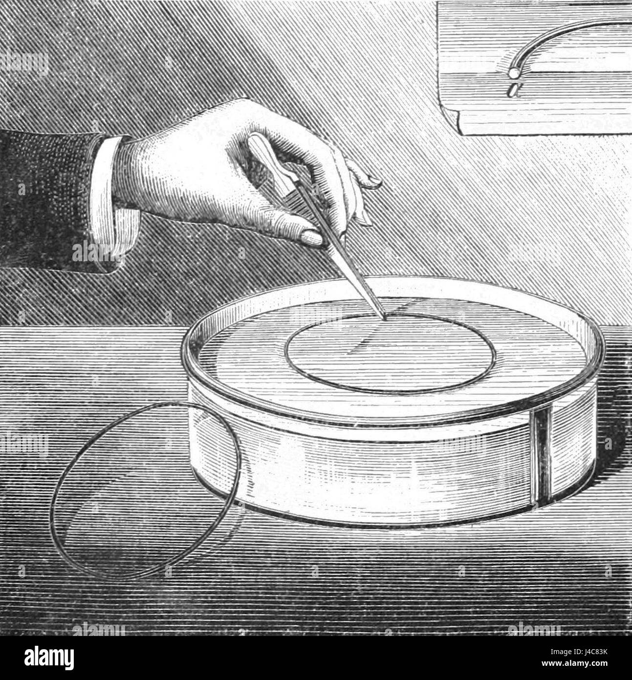 L'immagine presenta un anello di rame galleggiante sulla superficie dell'acqua, che illustra uno studio scientifico o un'interpretazione artistica della fluidodinamica o della tensione superficiale. Il comportamento flottante dell'anello metallico evidenzia i principi della fisica, in particolare la galleggiabilità e l'interazione superficiale tra solidi e liquidi. Foto Stock