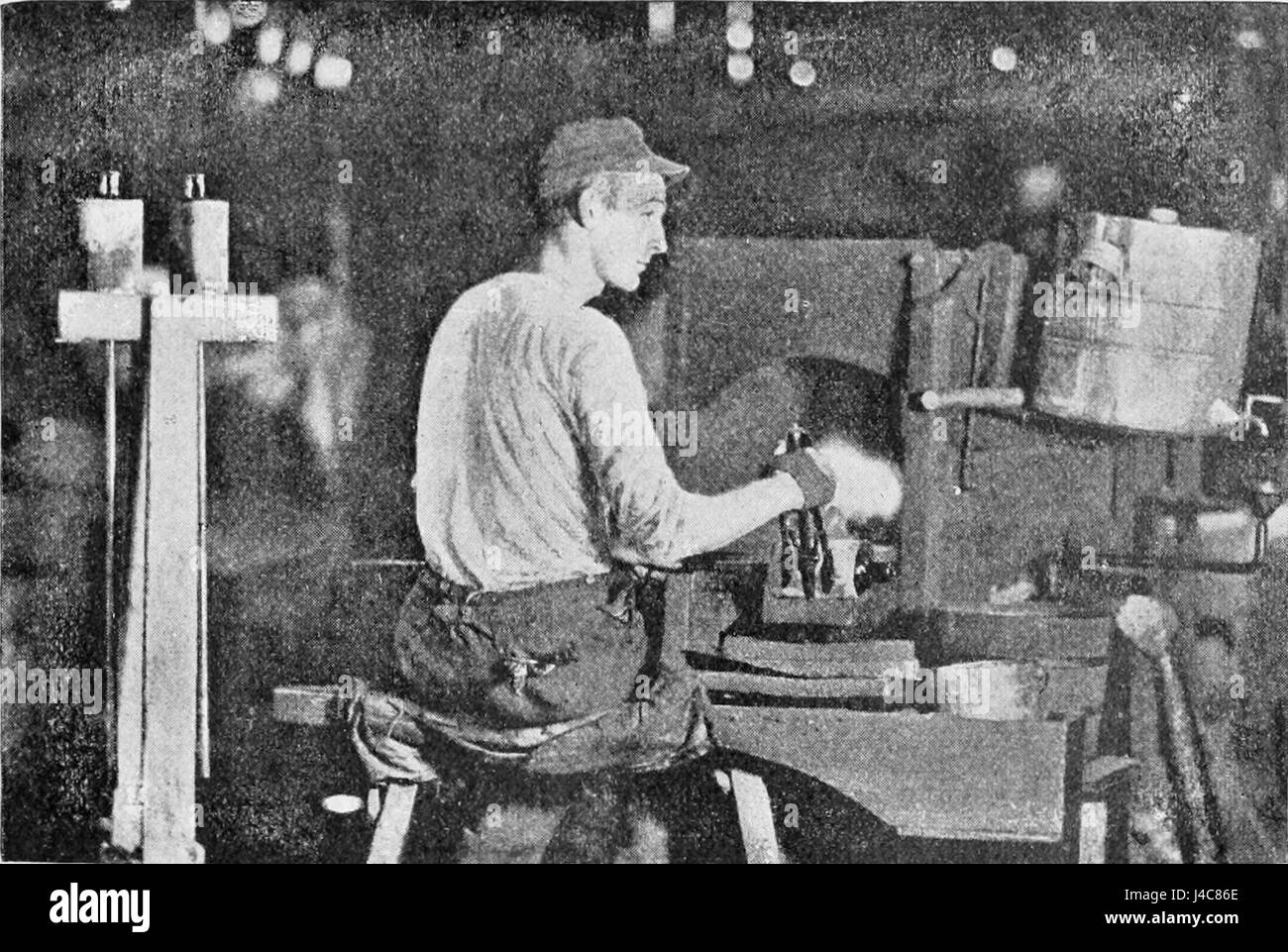 Questa immagine mostra un gaffer al lavoro, che mostra il mestiere dell'illuminazione nella produzione cinematografica e teatrale, evidenziando l'abilità e la precisione necessarie per creare un'illuminazione adeguata per una scena. Foto Stock