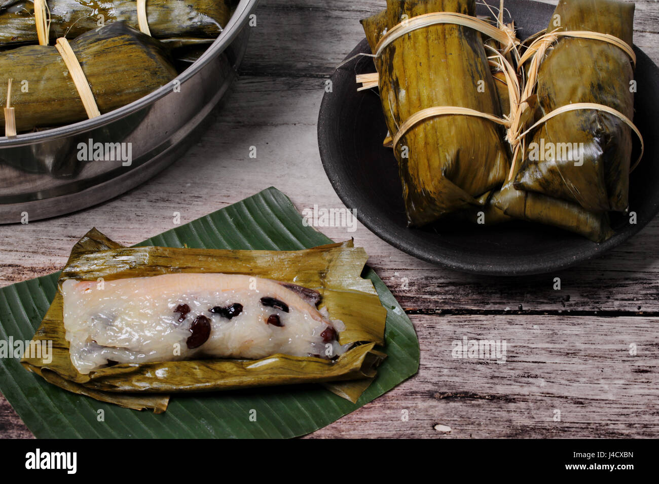 Popolari dessert Thai, in streaming di riso e fagioli neri in banana leaf chiamata Khao Tom Mad in thailandese servita sul piatto con cottura in pentola. Foto Stock
