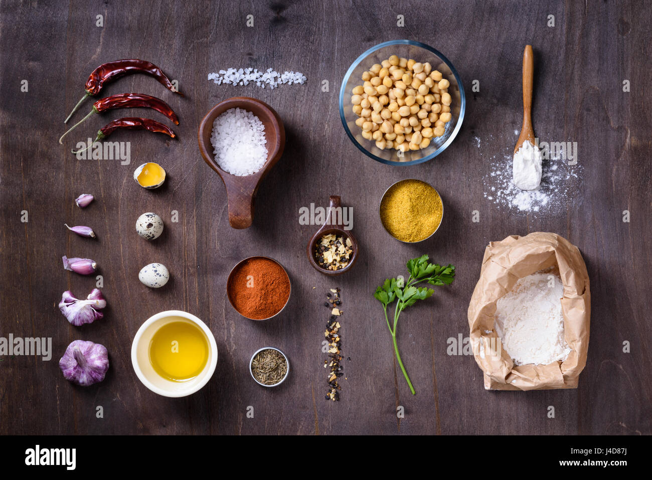 Materie di cottura Ingredienti laici piatto sul tavolo di legno. Ceci, uova, spezie, farina ed erbe aromatiche. Vista dall'alto. Foto Stock