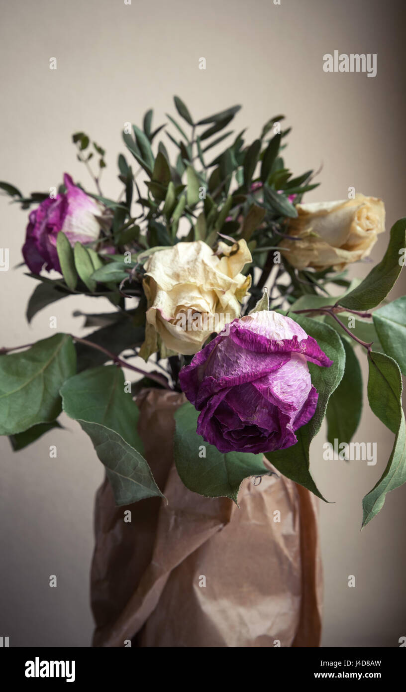 Bouquet di rossi secchi e rose bianche, primo piano verticale basso foto chiave oltre il muro grigio Sfondo, morbida messa a fuoco selettiva Foto Stock