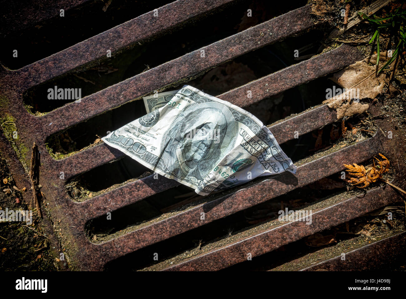 100-segno di dollaro in un Gulli, foto simbolico per l'US-crisi del debito, 100-Dollar-Note in einem Gulli, Symbolfoto fuer die US-Schuldenkrise Foto Stock