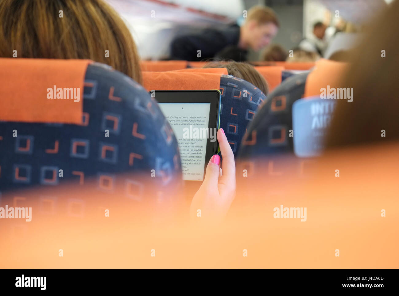 Persona la lettura di ebook sul volo di aeromobili Foto Stock