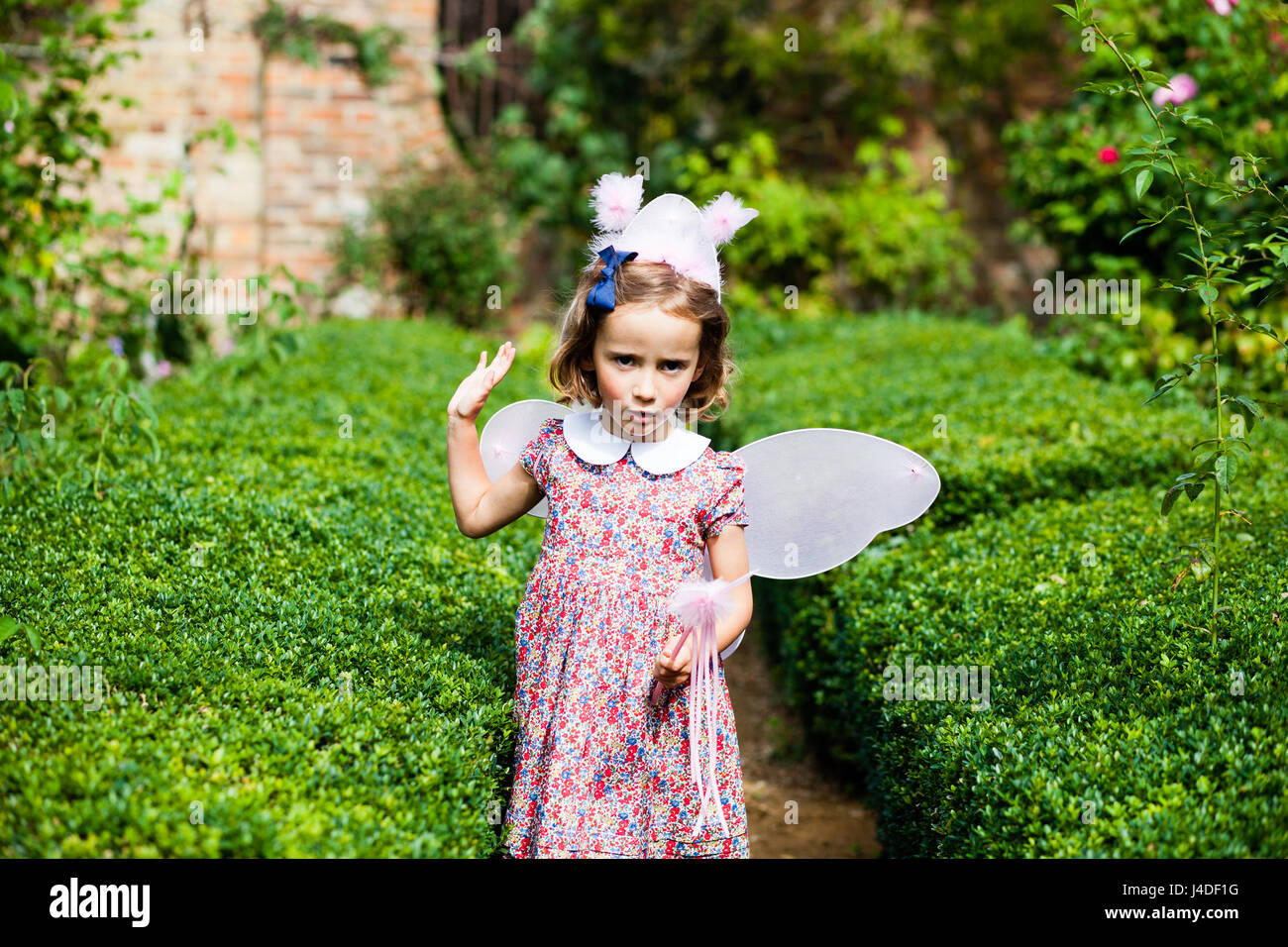 Vestirsi - Una bambina gioca come una fata in inglese il giardino estivo Foto Stock