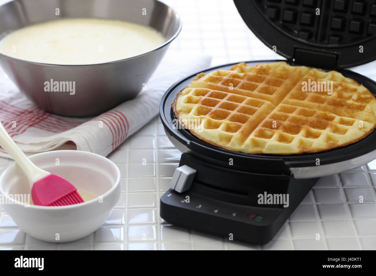 La preparazione di waffles fatti in casa da cialdiera macchina. Foto Stock