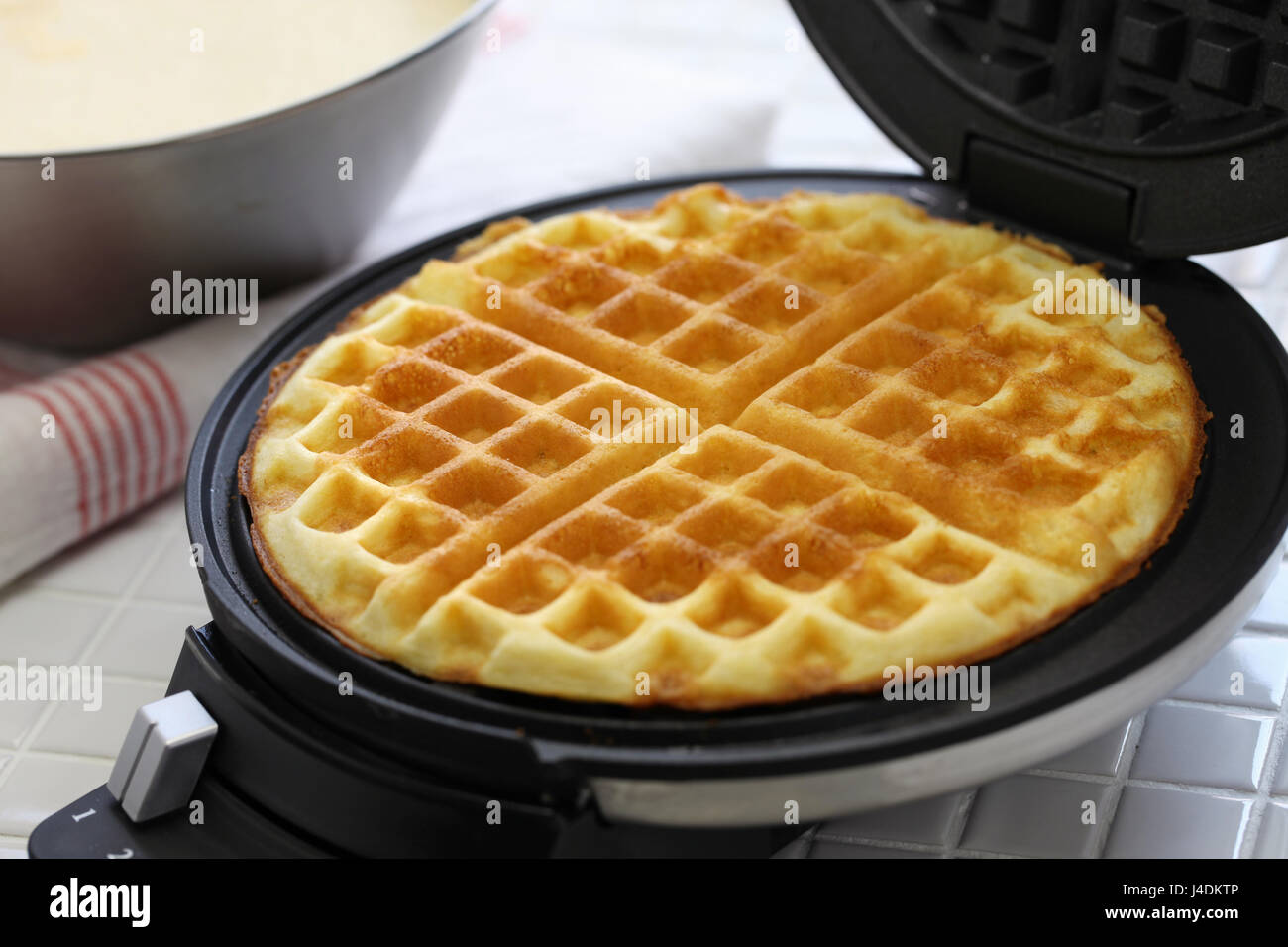 La preparazione di waffles fatti in casa da cialdiera macchina. Foto Stock