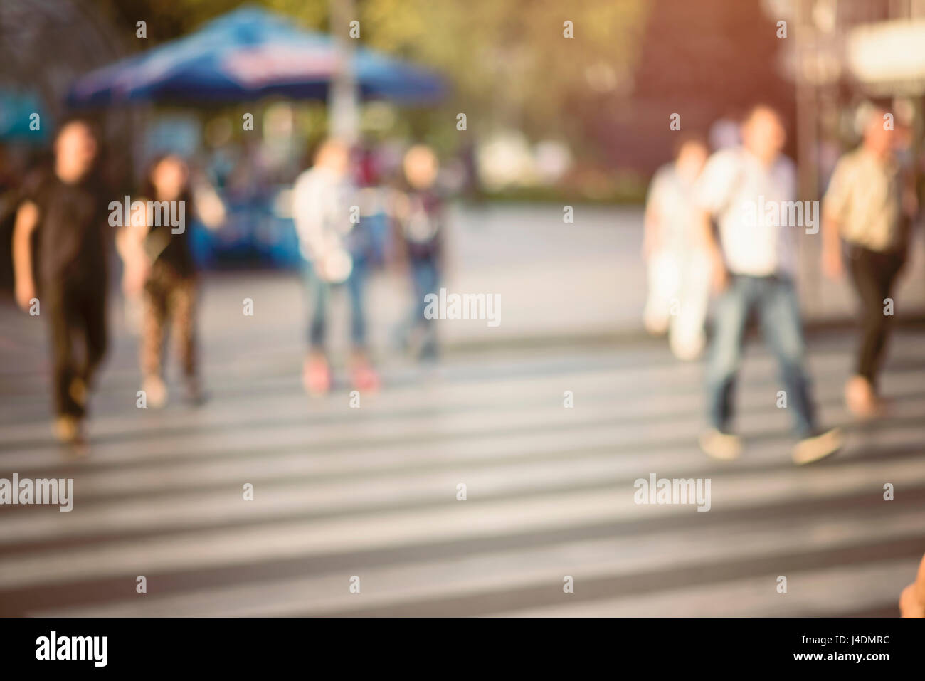 Irriconoscibile pedoni che attraversano la strada a zebra. sfondo sfocato di persone a piedi in strada. immagine filtrata con filtro vintage. Foto Stock