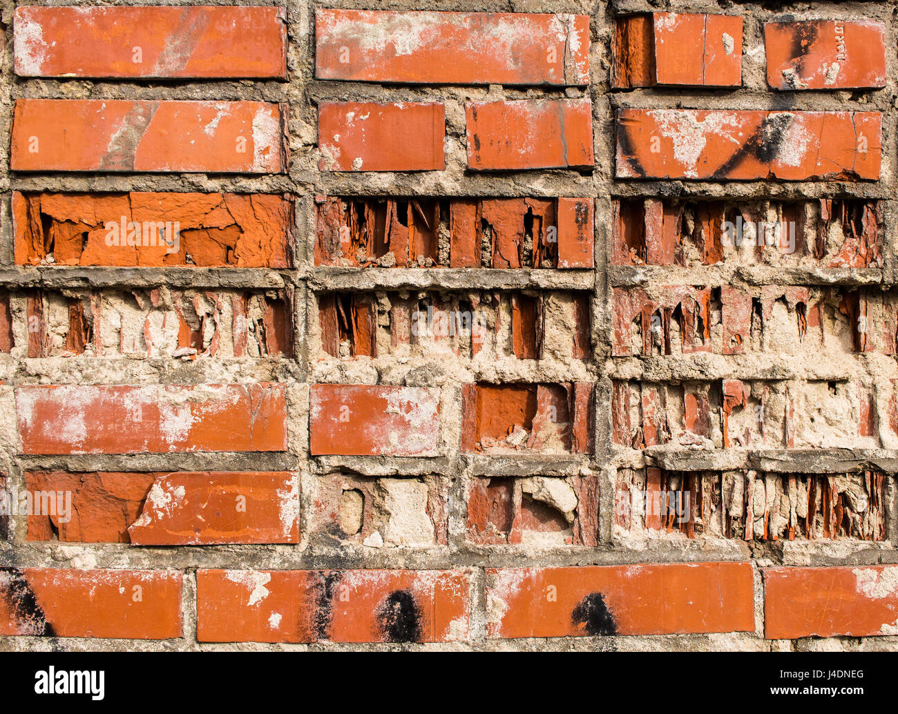 Un frammento di una parete da un vecchio rosso parzialmente distrutta in mattoni di argilla Foto Stock