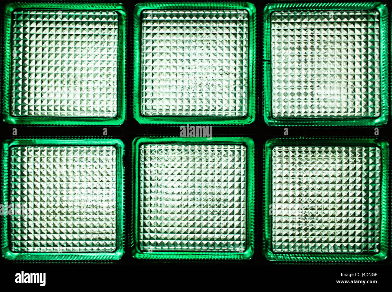 Sei verde trasparente blocchi di vetro. Un frammento di una parete di vetro con luce naturale che passa attraverso di esso. Foto Stock