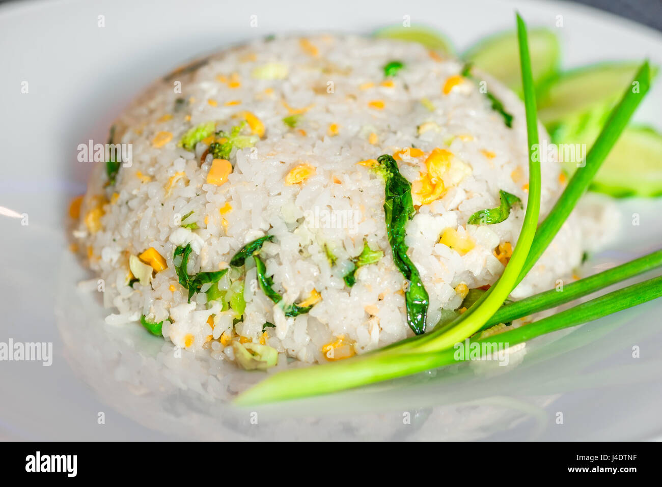 Riso con verdure in un ristorante tailandese close-up su una piastra bianca Foto Stock