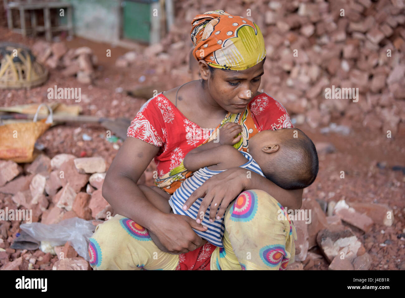 Dacca in Bangladesh. 13 Maggio, 2017. Dacca in Bangladesh - 13 Maggio 2017: un lavoro del Bangladesh madre che rompe i mattoni, si prende cura del suo bambino durante un tempo di interruzione a Dhaka, nel Bangladesh, 13 maggio 2017. La povera madre di lavoro non hanno accesso al centro diurno, e hanno così di portare con sé i propri figli. Credito: SK Hasan Ali/Alamy Live News Foto Stock