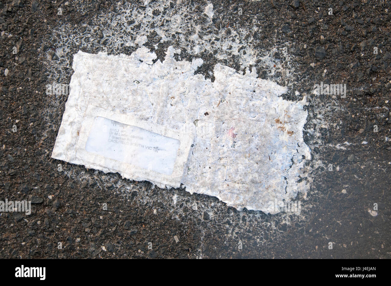 Poco riconoscibili come tali, una lettera sigillata giace scartati su una strada suburbana Foto Stock