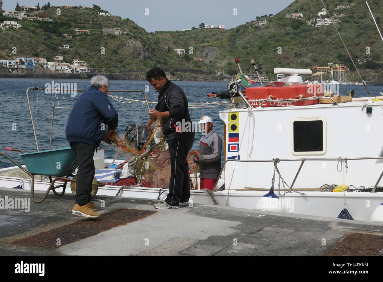 Pescatore in barca da pesca sul molo sull isola di Lipari, Isole Eolie, Italia. Foto Stock