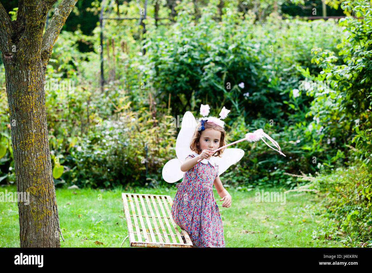 Vestirsi - Una bambina gioca come una fata in inglese il giardino estivo Foto Stock