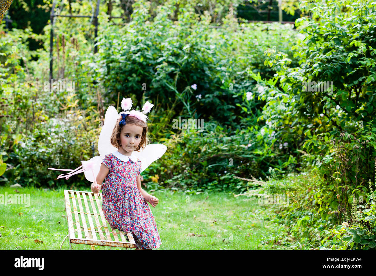 Vestirsi - Una bambina gioca come una fata in inglese il giardino estivo Foto Stock