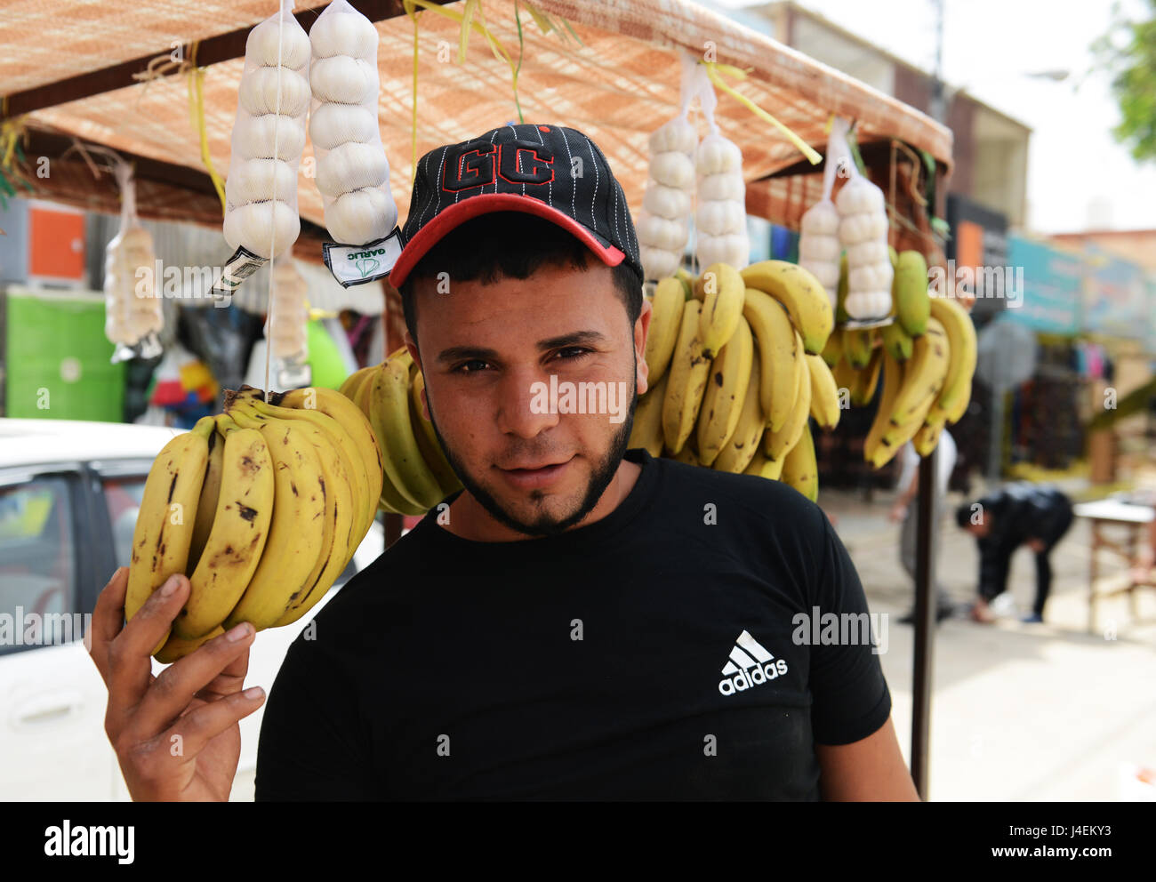 Un giovane venditore giordani la vendita delle banane. Foto Stock