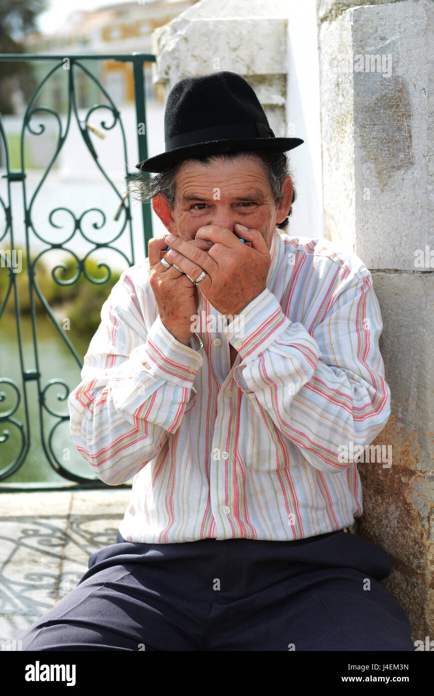 Un musicista di strada a suonare la sua armonica in Ayamonte, Spagna. Foto Stock