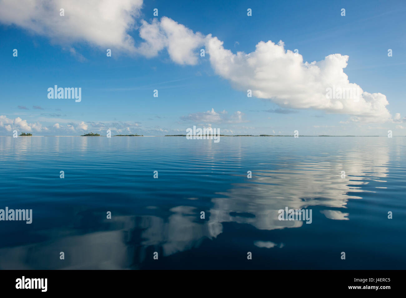 Nuvole che riflettono nelle calme acque di Tikehau, Tuamotus, Polinesia francese, Pacific Foto Stock