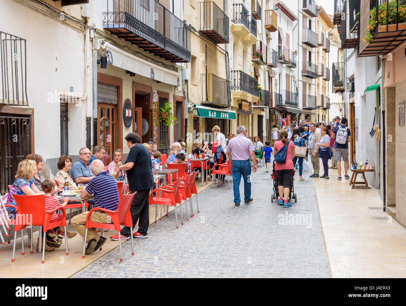 Occupato cafè e negozio rivestita strada pedonale, Carrer de Sant Julia, Morella, Spagna Foto Stock
