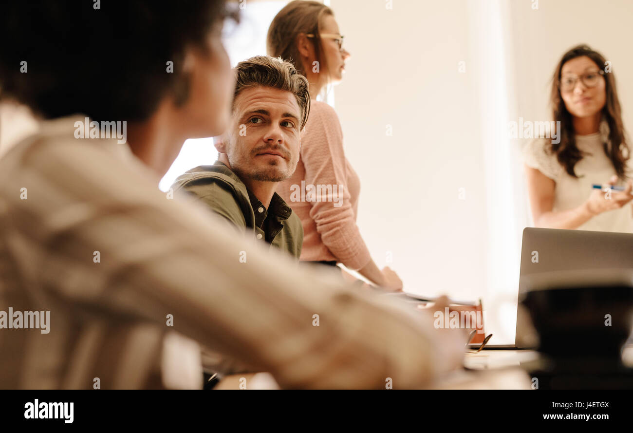 Giovane uomo durante la riunione di affari. Team aziendale riuniti nella sala conferenze. Foto Stock