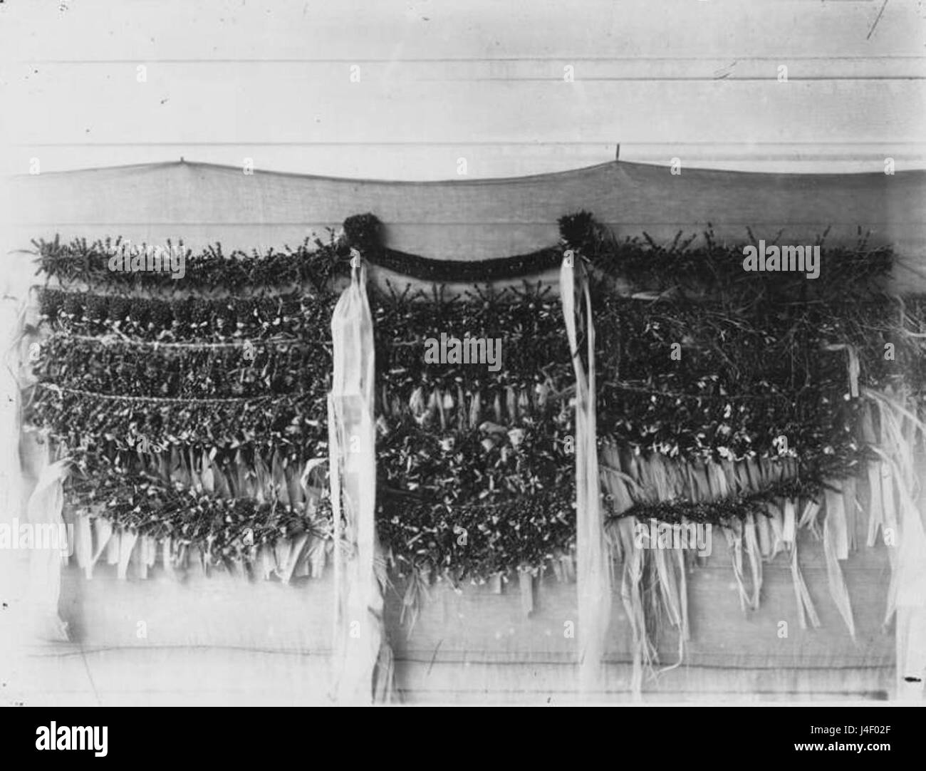 Fotografata da Francis Sinclair nel 1885, questa immagine mostra le tradizionali decorazioni hawaiane fatte a mano montate su una parete. Questi oggetti riflettono l'artigianato e il patrimonio culturale delle Hawaii alla fine del XIX secolo. Foto Stock