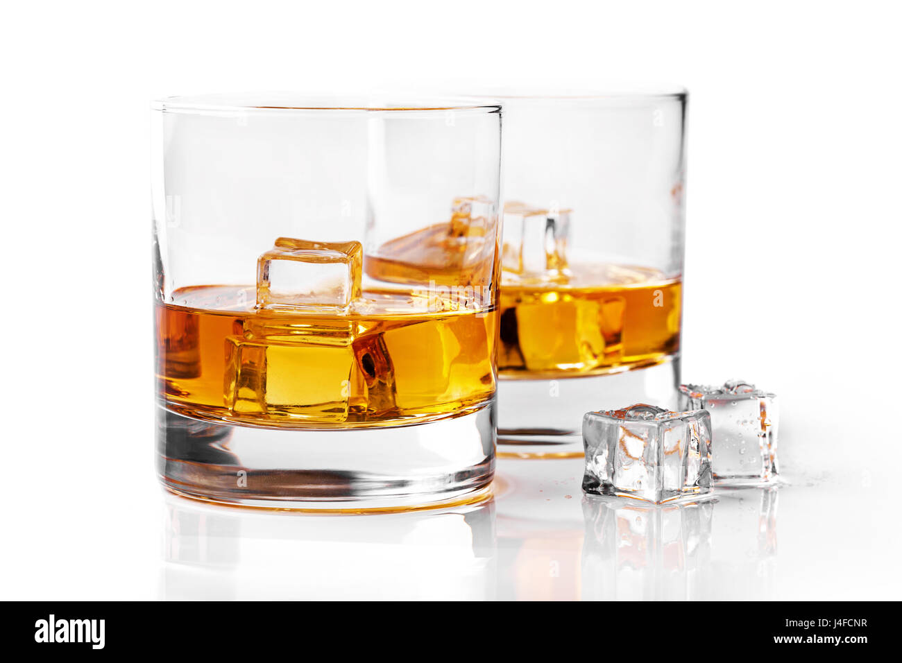 Bicchieri di whiskey con cubetti di ghiaccio isolato su sfondo bianco Foto Stock