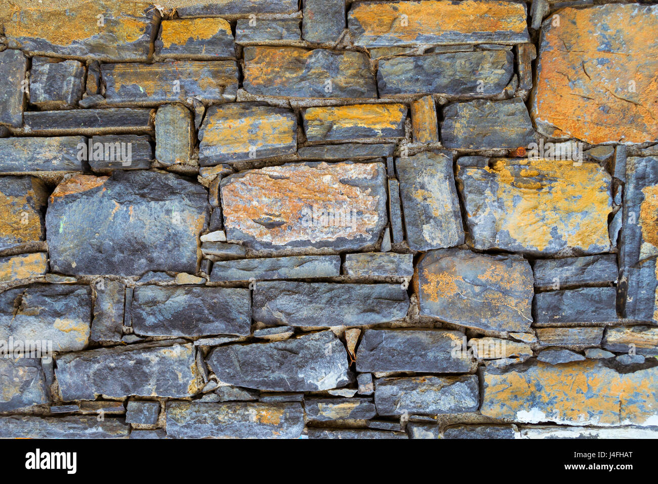 Tessitura della pietra di granito parete per background creativo. Dark pietre monolitico uniti con cemento in un unico pannello di pietra. Architettura greca, Bali, Cr Foto Stock