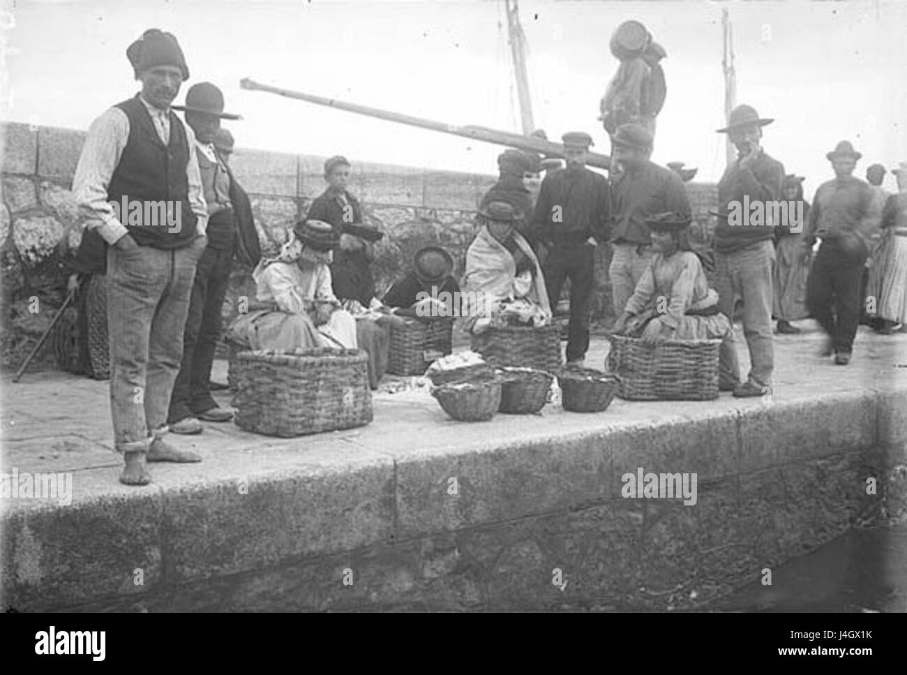 "Sardinieres a Lisbonne" è una fotografia in bianco e nero che cattura un gruppo di pescatori di sardine a Lisbona, Portogallo. L'immagine offre uno sguardo sull'industria della pesca e sulla vita quotidiana di Lisbona all'inizio del XX secolo. Foto Stock