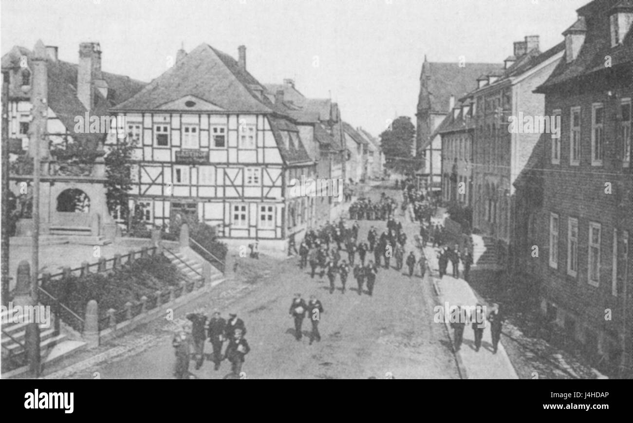 Questa immagine storica raffigura la strada Steinweg con il Papedenkmal (Monumento del Papa) intorno al 1906. Il monumento, che probabilmente commemora una significativa figura religiosa o politica, si trova in una strada che sembra far parte di un paesaggio urbano europeo dei primi anni del XX secolo. L'immagine offre uno sguardo sullo sviluppo urbano e sul contesto sociale del tempo. Foto Stock