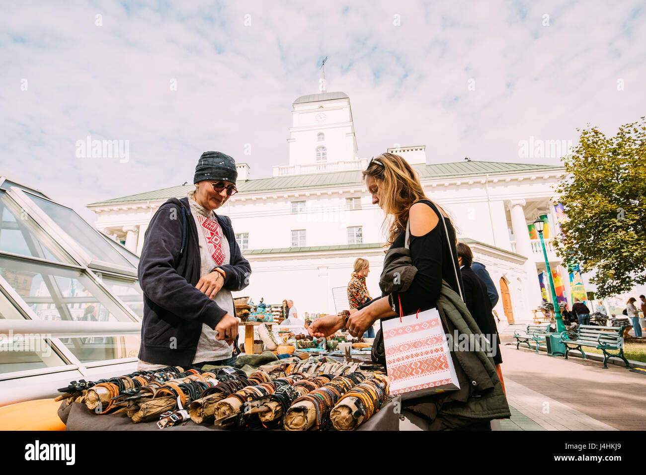 Minsk, Bielorussia - 3 Settembre 2016: Donna di acquisto di souvenir sulla strada del mercato di Piazza della Libertà nei pressi del Municipio. Trading di vassoi con vendita di doni, dolce Foto Stock