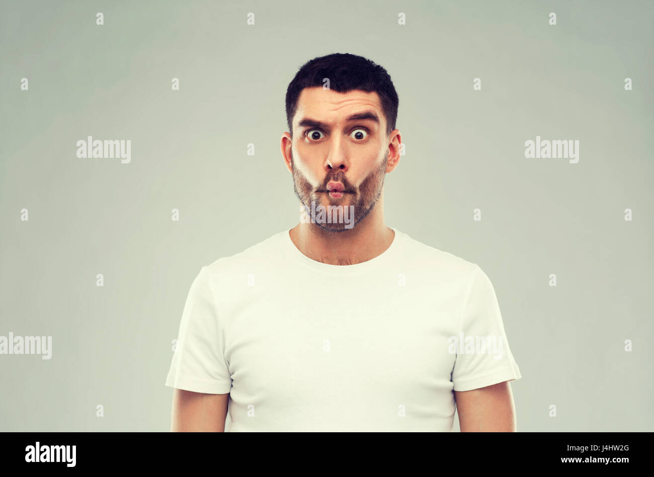 L'uomo con il pesce faccia su sfondo grigio Foto Stock